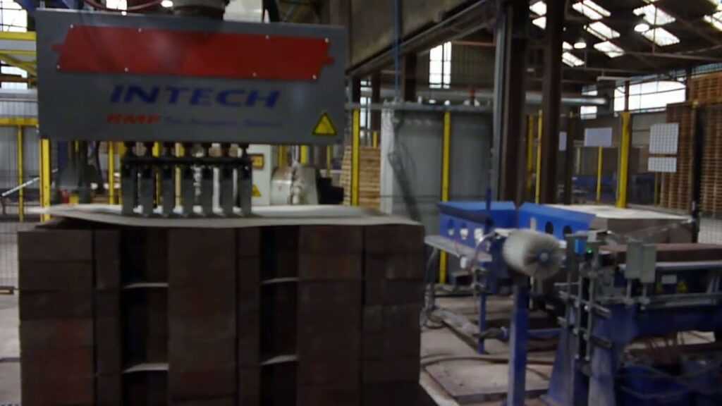 Robotinstallatie met speciale klem-grijper die klinkers en stenen tot machinale pakketten palletiseert